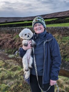 Mally the white Bichon Frise is held by his owner