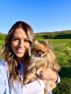 Primrose the orange sable Pomeranian gets a cuddle from her owner