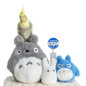 Yellow and Grey Pied Pearl Cockatiel sitting with stuffed toys