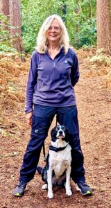Black and White Border Collie standing between the legs of a blonde lady