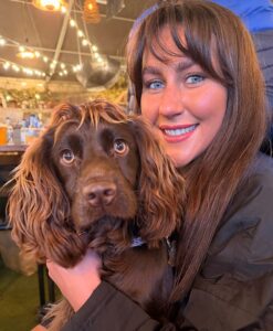 Chocolate Working Cocker Spaniel posing with her owner
